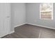 Bedroom with a window, blinds, door, and light gray walls with wood-style flooring at 204 Brooks Rd, Frostproof, FL 33843