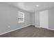 Bright bedroom with wood style floors, a window with blinds, and gray walls at 204 Brooks Rd, Frostproof, FL 33843