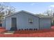 Home exterior showcasing gray siding, dark trim, walkway to door, and landscaping at 204 Brooks Rd, Frostproof, FL 33843