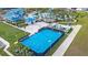 Aerial view of a vibrant blue basketball court surrounded by lush greenery and palm trees at 207 Jetty Way, Davenport, FL 33897