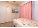 Bedroom with carpet flooring, sheer pink curtains and a ceiling fan at 207 Jetty Way, Davenport, FL 33897