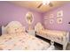 Bedroom featuring two twin beds with princess bedding, a ceiling fan and lavender colored walls at 207 Jetty Way, Davenport, FL 33897