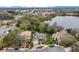 An aerial view of the home featuring mature landscaping, nearby water features, and a paver driveway at 210 Laurel Park Ct, Winter Park, FL 32792