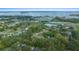 An aerial view shows the property with a tree-covered lot, and nearby expressway with lake views at 212 Glenn St, Leesburg, FL 34748