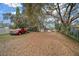 Large, wooded backyard with a red truck parked alongside the property line at 212 Glenn St, Leesburg, FL 34748