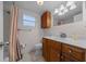 Functional bathroom featuring a wooden vanity with a sink and shower with white tiling at 212 Glenn St, Leesburg, FL 34748