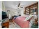 Bright bedroom featuring a ceiling fan, hardwood floors, and a built-in bookshelf at 212 Glenn St, Leesburg, FL 34748