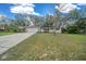 Charming single-story home with a well-manicured lawn, a paved driveway, and mature trees at 212 Glenn St, Leesburg, FL 34748