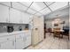 Classic kitchen featuring bright cabinets, tile flooring, and a dining area in an open concept layout at 212 Glenn St, Leesburg, FL 34748