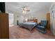 A serene main bedroom boasts a ceiling fan, chair, and neutral tones, creating a relaxing retreat at 212 Glenn St, Leesburg, FL 34748