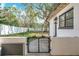 Lush backyard enclosed by a white fence, featuring mature trees and a secure gated entrance at 213 James Dr, Winter Garden, FL 34787