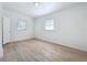 Neutral bedroom with wood-look flooring features two windows and a white door at 213 James Dr, Winter Garden, FL 34787