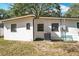 Rear exterior of the home, showing an air conditioning unit, a few windows, and a bench at 213 James Dr, Winter Garden, FL 34787