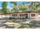 Inviting single-story home featuring brick walkway, manicured landscaping, and a covered carport at 213 James Dr, Winter Garden, FL 34787