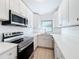 Well-lit kitchen featuring stainless steel appliances, white cabinetry and light countertops at 213 James Dr, Winter Garden, FL 34787