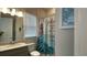 Bathroom vanity featuring a granite countertop, modern lighting, and a mermaid shower curtain at 2132 Limestone Trl, Kissimmee, FL 34747