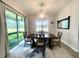 A well-lit dining room with stylish rug beneath a wooden dining table and sliding glass door to the backyard at 2132 Limestone Trl, Kissimmee, FL 34747