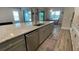 Close-up of kitchen island featuring granite countertops, a stainless steel dishwasher, and ample storage at 2132 Limestone Trl, Kissimmee, FL 34747