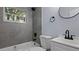 This bathroom offers gray wall tiling, modern fixtures, and a bright window at 25 N Van Buren Ave, Orlando, FL 32811