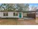 Charming single-story home featuring a teal-colored front door, carport, and freshly painted white exterior at 25 N Van Buren Ave, Orlando, FL 32811