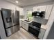 Modern kitchen featuring stainless steel appliances, white cabinets, and quartz countertops at 25 N Van Buren Ave, Orlando, FL 32811