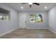 Bright living room featuring wood-look flooring, natural light, and light gray walls at 25 N Van Buren Ave, Orlando, FL 32811