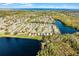 An aerial view of a neighborhood with a lake and beautiful landscaping under a blue sky at 259 Southbridge Cir, Kissimmee, FL 34744