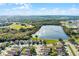 Aerial view of a neighborhood with a lake and beautiful landscaping under a blue sky at 259 Southbridge Cir, Kissimmee, FL 34744