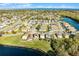 Aerial view of a neighborhood with a lake and tree lined streets and canals under a blue sky at 259 Southbridge Cir, Kissimmee, FL 34744