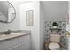 Half bathroom featuring a toilet, sink, decorative mirror and wallpaper at 259 Southbridge Cir, Kissimmee, FL 34744