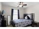 Cozy bedroom features a patterned comforter, ceiling fan, and natural light from the window at 259 Southbridge Cir, Kissimmee, FL 34744