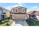 Exterior front view of home, showcasing neutral paint, two-car garage, solar panel and landscaping at 259 Southbridge Cir, Kissimmee, FL 34744