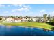 Back view of homes with lake views, lush lawns, and mature trees at 259 Southbridge Cir, Kissimmee, FL 34744