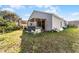 View of the home's exterior with a wooden-covered patio and lawn at 2957 Birmingham Blvd, Orlando, FL 32829