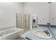 Bathroom with tiled tub, glass enclosed shower, and large vanity area at 2957 Birmingham Blvd, Orlando, FL 32829