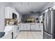 Modern kitchen flowing to living area, featuring stainless appliances and tile flooring at 2957 Birmingham Blvd, Orlando, FL 32829