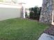 Landscaped backyard with green grass, a rock wall and black fence at 318 Habitat Way, Sanford, FL 32773