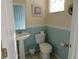 Half bathroom featuring a pedestal sink, toilet, and a light blue accent wall at 318 Habitat Way, Sanford, FL 32773