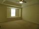 Carpeted bedroom featuring tray ceilings, a ceiling fan, and a large window at 318 Habitat Way, Sanford, FL 32773