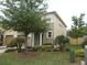 Exterior of home with a well-manicured lawn, lush trees, and beautiful landscaping at 318 Habitat Way, Sanford, FL 32773