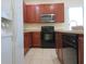 Bright kitchen featuring a black oven and microwave, stainless steel sink, and tiled floors at 318 Habitat Way, Sanford, FL 32773