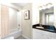 Bright bathroom featuring a shower-tub, white vanity with black countertop and a striking geometric patterned floor at 322 E Central Blvd # 1612, Orlando, FL 32801