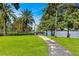 Scenic view of the park featuring lush greenery, palm trees, and a paved pathway leading to the lake at 322 E Central Blvd # 1612, Orlando, FL 32801