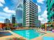 View of the pool with lush landscaping, lounge chairs and high-rise buildings at 322 E Central Blvd # 1612, Orlando, FL 32801