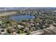 Aerial view of a home with a pool surrounded by mature trees and situated near a tranquil lake at 4124 Winderlakes Dr, Orlando, FL 32835