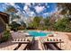 Lush backyard with a beautiful pool, charming patio, and comfortable lounge chairs for relaxation at 4124 Winderlakes Dr, Orlando, FL 32835