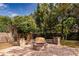 Cozy fire pit area with stone seating, set in a brick patio and surrounded by lush greenery at 4124 Winderlakes Dr, Orlando, FL 32835