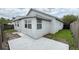 Exterior view of the house with concrete patio, fenced yard, and light grey paint at 458 Lancers Dr, Winter Springs, FL 32708