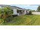 Manicured backyard with a covered outdoor kitchen, lush green lawn, and privacy landscaping at 4789 Terrace Bluff St, Winter Garden, FL 34787