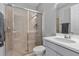 Bathroom featuring a glass-enclosed shower, neutral tiling, and a white vanity with sink and modern fixtures at 4789 Terrace Bluff St, Winter Garden, FL 34787